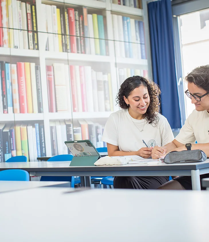 Bibliothek: Zwei Lernende am Tablet