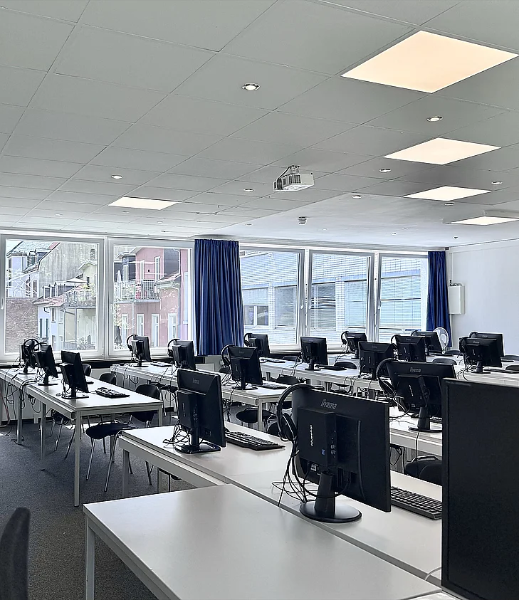 Computerraum: Bildschirmreihen mit Straßenblick